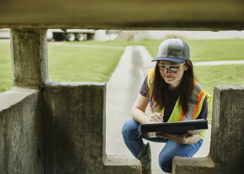 Woman in a hat and safety vest examining foundation