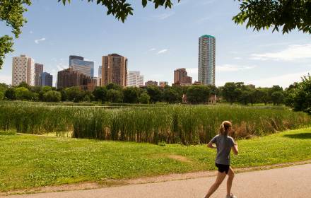 Person running on a residential trail with a cityscape in the background