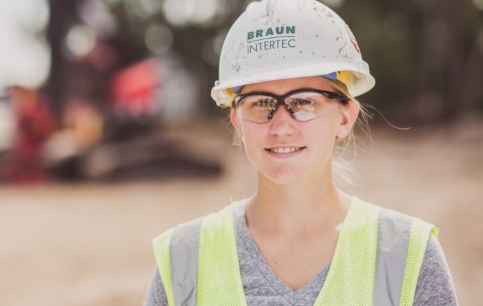 Braun Intertec employee in a hard hat, safety glasses and vest