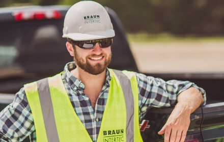 Braun employee smiling in a hardhat, sunglasses and Braun vest
